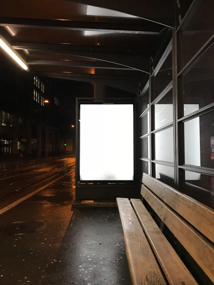 A lit blank billboard on a street at night.