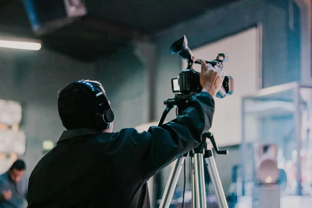 A camera operator filming in a studio.