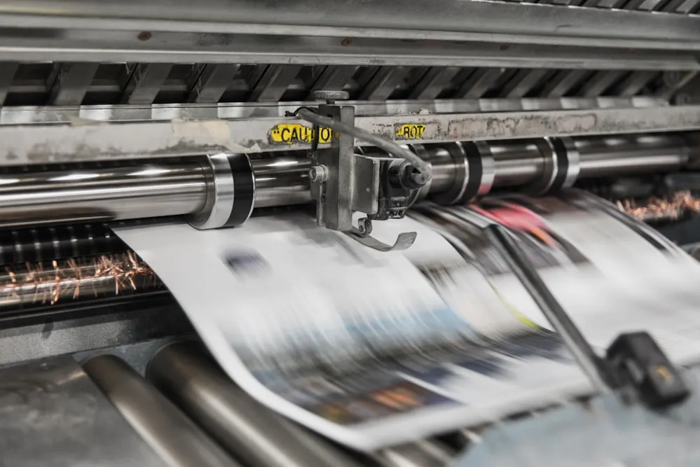 Newspapers running through a printing press.