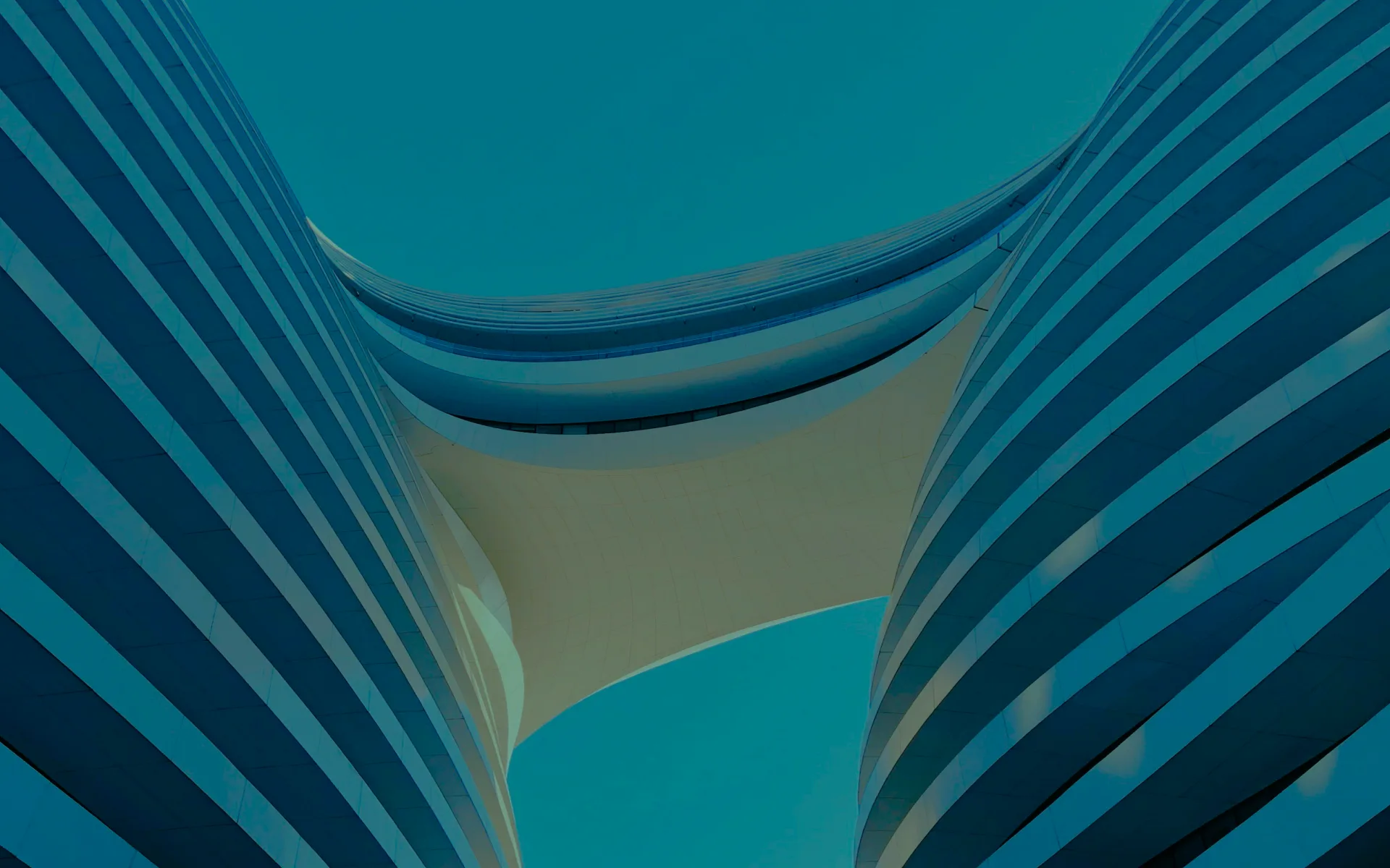 Two curved office towers with striped facades, seen from below.