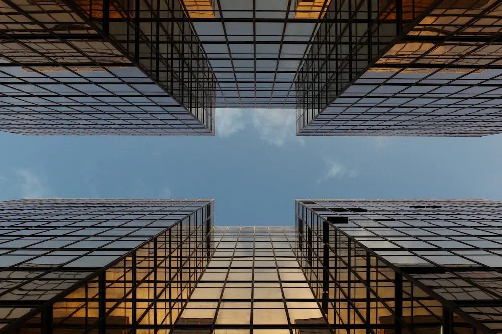 Two office blocks seen from the ground between them.