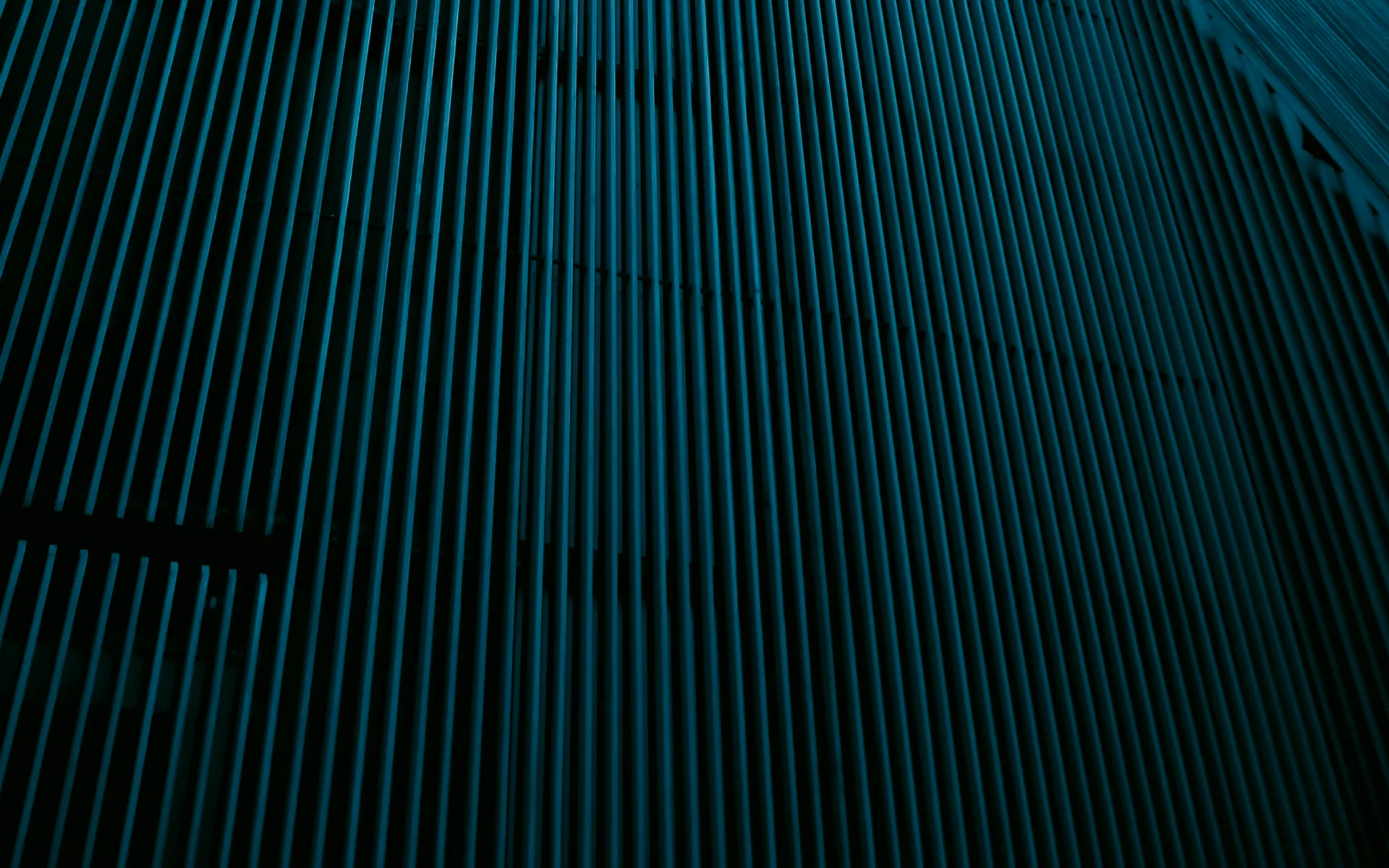 The corner of a glass and metal tower, seen from below.