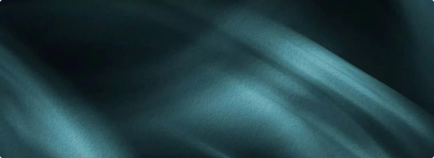 Folded teal silk lit from the side.