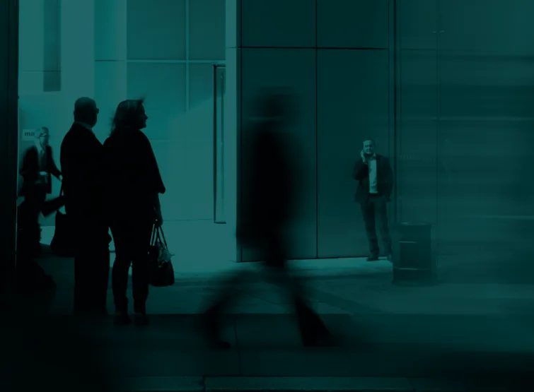People walking past an office entrance, caught mid-stride.
