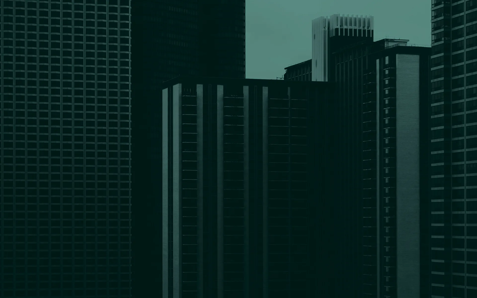 Dark office towers packed together, seen from street level.