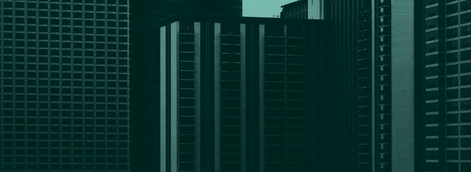 Dark office towers packed together, seen from street level.