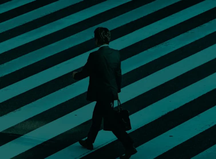 A person crossing a wide zebra crossing, seen from above.