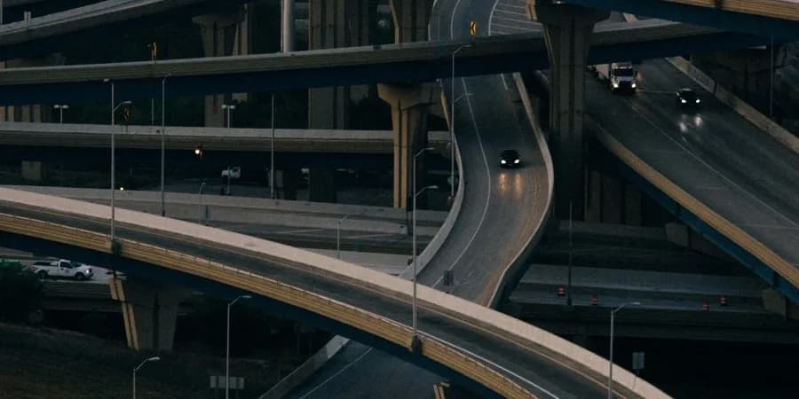 Curved motorway ramps at night, seen from above.