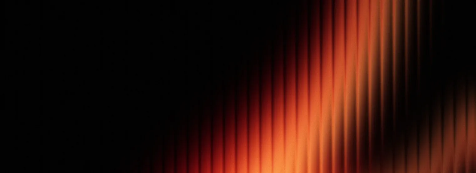 Pleated fabric lit orange from one side.