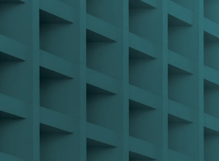 A white concrete facade of repeating square recesses.