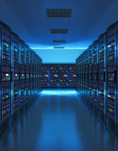 A data centre aisle lined with server racks, lit from above in blue.