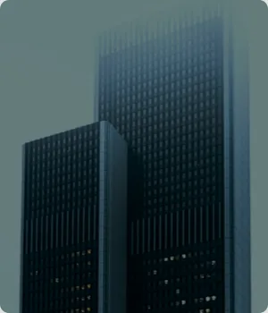 Two tall office towers in fog.
