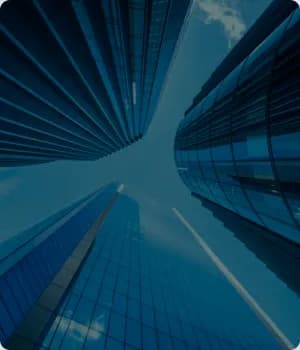 Glass towers seen from below against the sky.