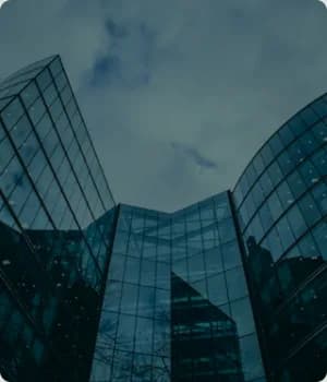 Two glass office towers seen from ground level.
