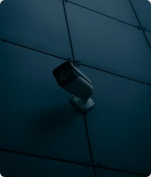 A security camera on a flat panel wall.