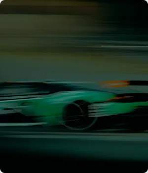 A race car passes with motion blur.