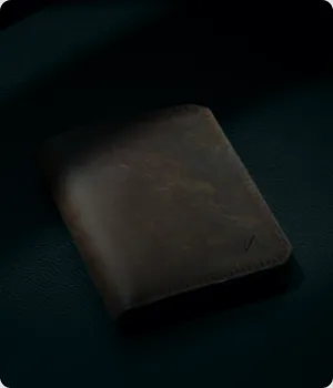 A folded leather wallet lies on a flat surface.